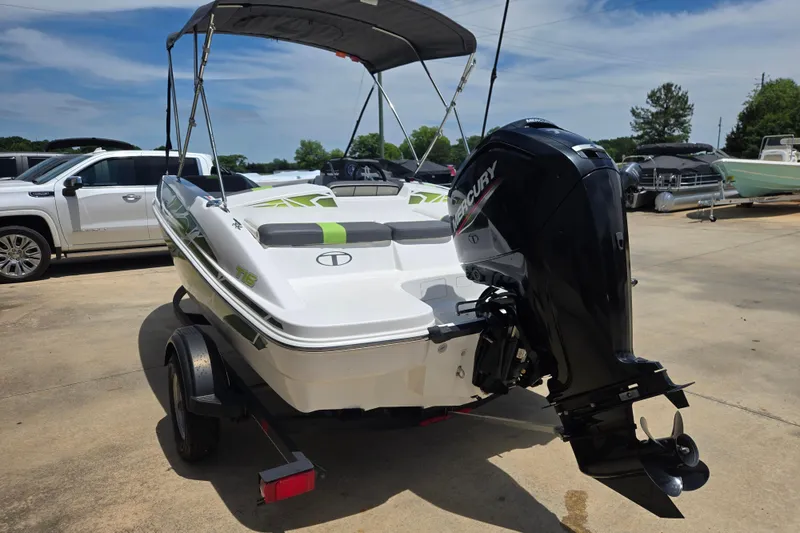 Slide: The Image of 2022 Tahoe T16 boat with Mercury outboard motor on trailer, parked outdoors. - 3