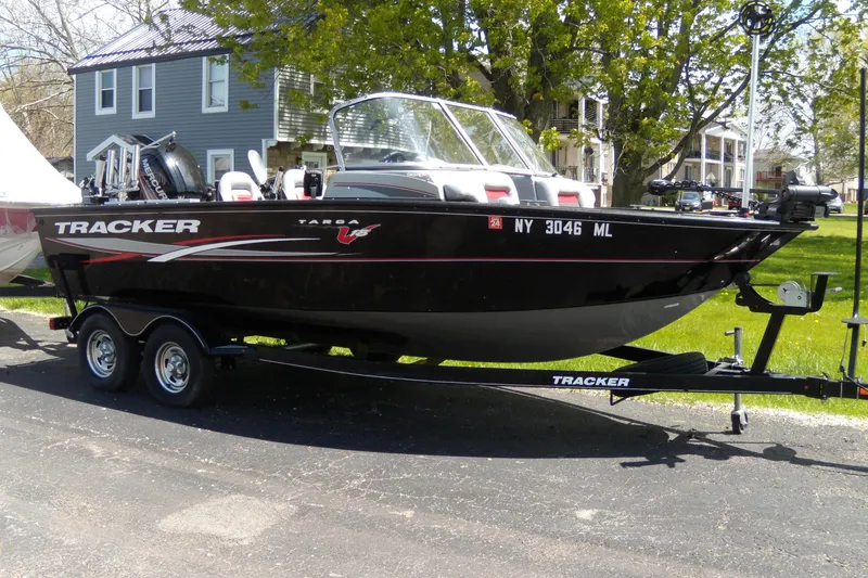 The Image of 2016 Tracker Targa V-18 WT boat on trailer, parked outdoors near houses. - 0