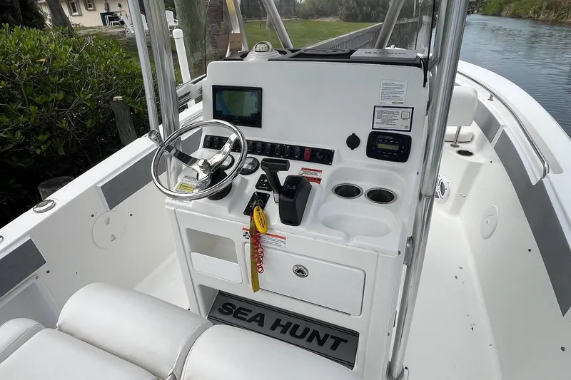 Slide: The Image of 2015 Sea Hunt Ultra 211 boat console with steering wheel and navigation controls. - 13