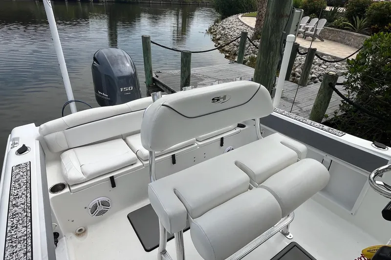 Slide: The Image of 2015 Sea Hunt Ultra 211 boat interior with Yamaha 150 engine, docked by a serene waterfront. - 15