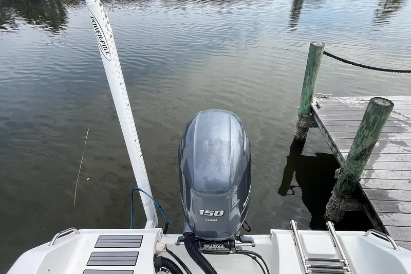 Slide: The Image of 2015 Sea Hunt Ultra 211 boat with Yamaha 150 engine docked by wooden pier. - 16
