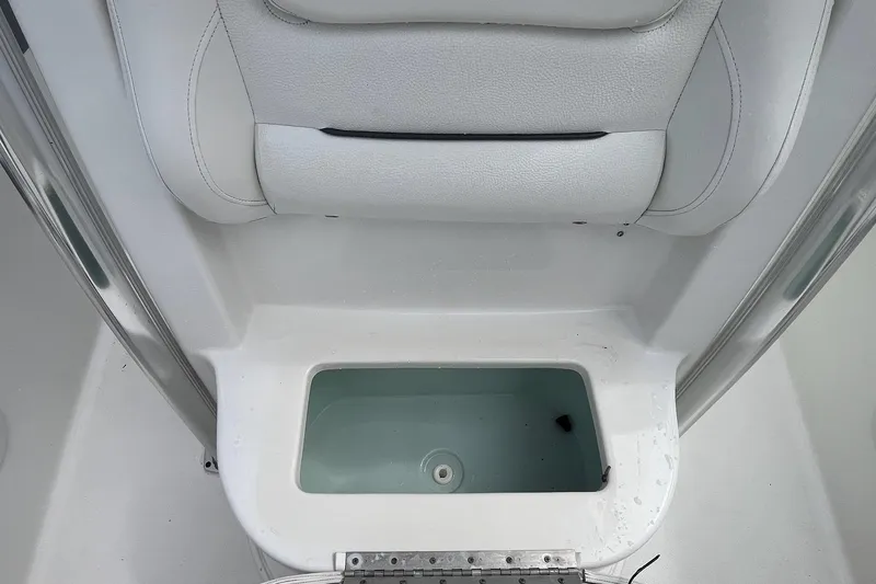 Slide: The Image of Interior view of a 2015 Sea Hunt Ultra 211 boat, featuring a white cushioned seat and storage compartment. - 6