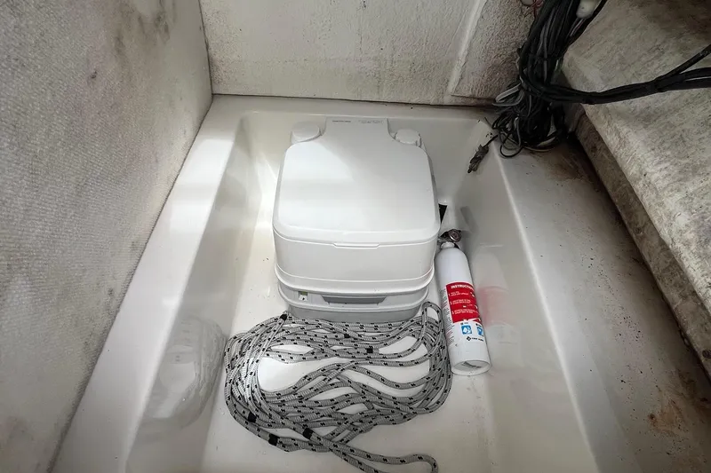 Slide: The Image of Portable toilet and fire extinguisher in 2015 Sea Hunt Ultra 211 boat compartment. - 7