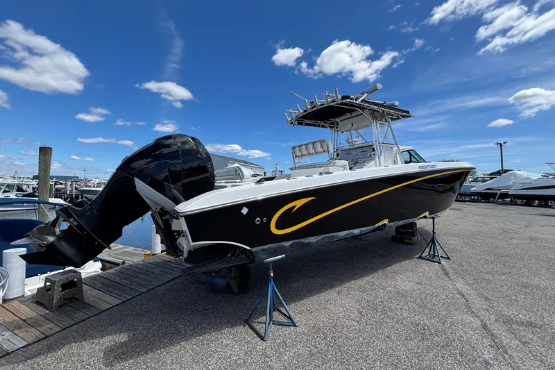 Slide: The Image of 2007 Fountain 34 Center Console boat on display at a marina under a clear blue sky. - 1