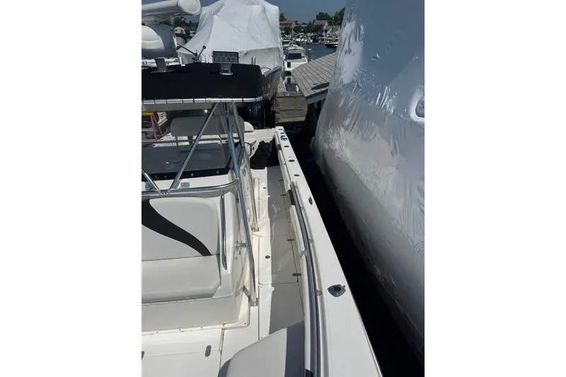 Slide: The Image of 2007 Fountain 34 Center Console boat docked, showcasing sleek design and spacious deck. - 12
