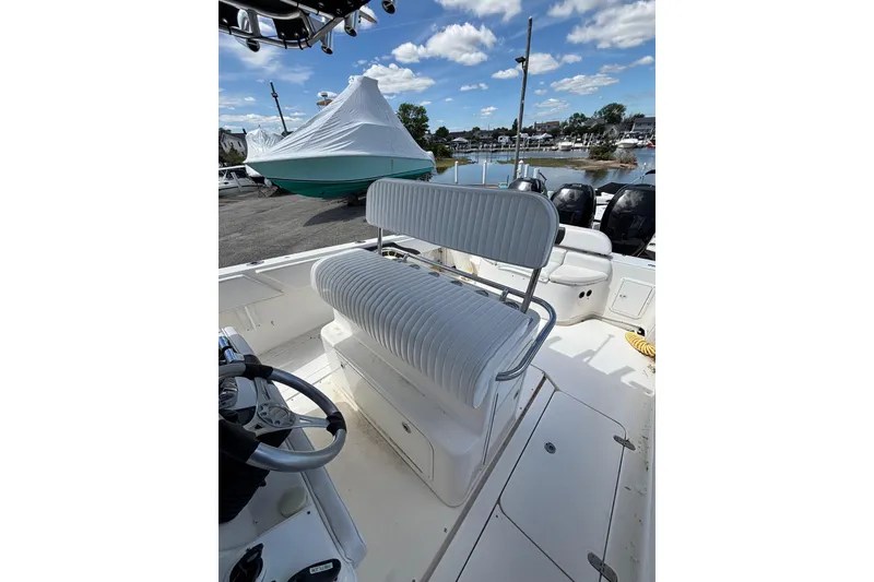 Slide: The Image of 2007 Fountain 34 Center Console boat interior with seating and steering wheel, docked near water. - 13