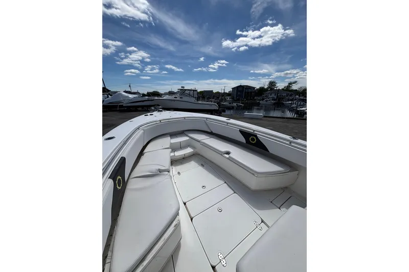 Slide: The Image of 2007 Fountain 34 Center Console boat with spacious seating, docked under a partly cloudy sky. - 14
