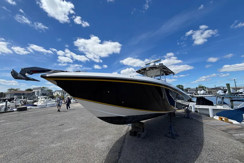 Slide: The Image of 2007 Fountain 34 Center Console boat on display at a marina under a clear blue sky. - 2
