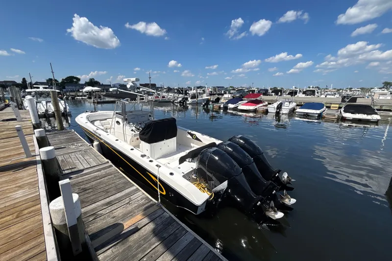 Slide: The Image of 2007 Fountain 34 Center Console boat docked at a marina under a clear blue sky. - 4