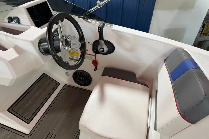Slide: The Image of 2024 Tahoe T18 boat interior with steering wheel, control panel, and cushioned seating. - 11