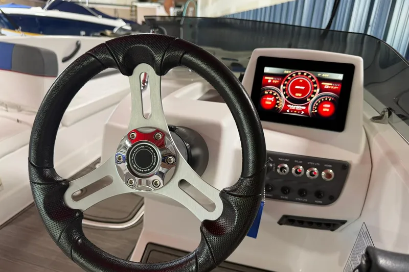 Slide: The Image of 2024 Tahoe T18 boat dashboard with steering wheel and digital display. - 12