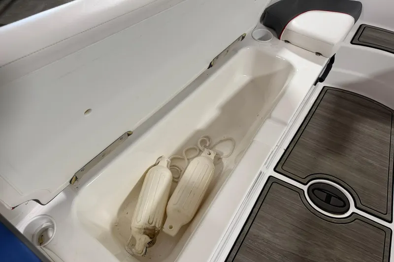 Slide: The Image of 2024 Tahoe T18 boat storage compartment with fenders and cushioned seating. - 6