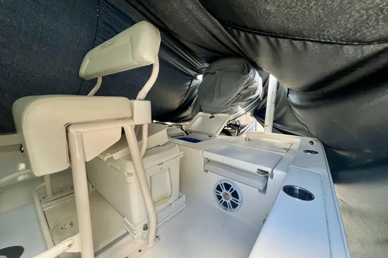 Slide: The Image of Interior of a 2017 Pathfinder 2400 TRS boat under cover, featuring seating and storage. - 2