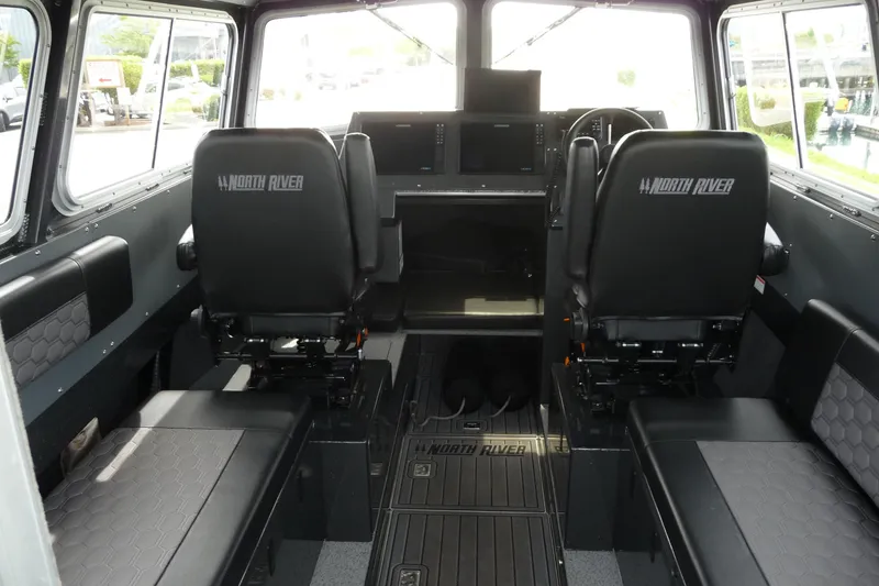 Slide: The Image of Interior of 2025 North River 2700s boat, featuring modern seating and control panel. - 10