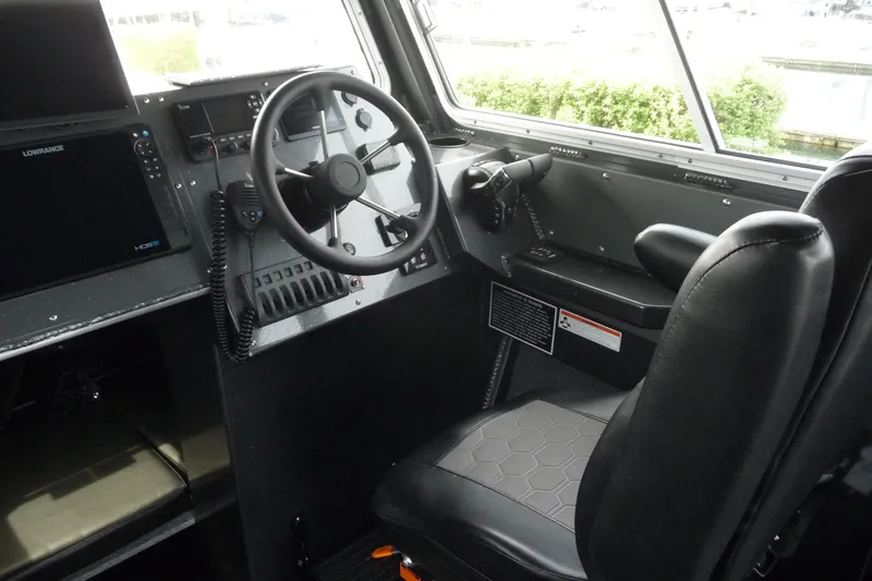 Slide: The Image of Interior cockpit of 2025 North River 2700s boat with steering wheel and navigation equipment. - 11