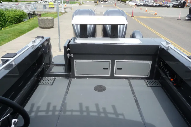Slide: The Image of 2025 North River 2700s boat deck with dual engines, docked at a marina. - 14