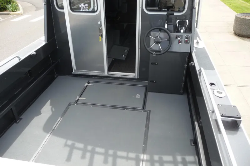 Slide: The Image of 2025 North River 2700s boat interior with steering wheel and storage compartments. - 15