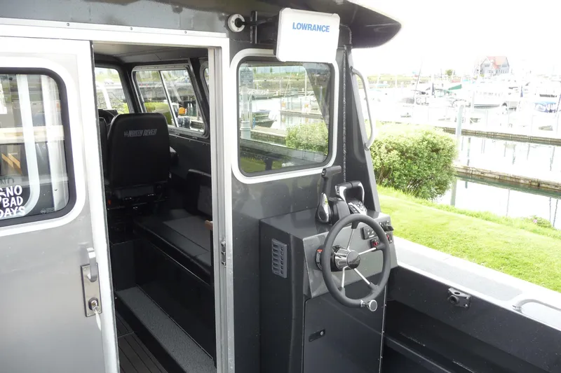 Slide: The Image of Interior view of a 2025 North River 2700s boat, featuring steering controls and seating. - 17