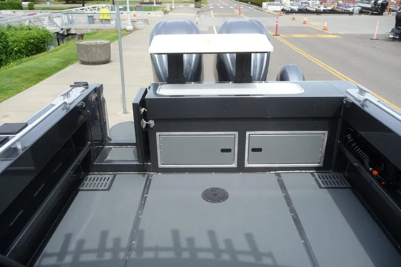 Slide: The Image of 2025 North River 2700s boat deck with storage compartments and dual engines. - 18