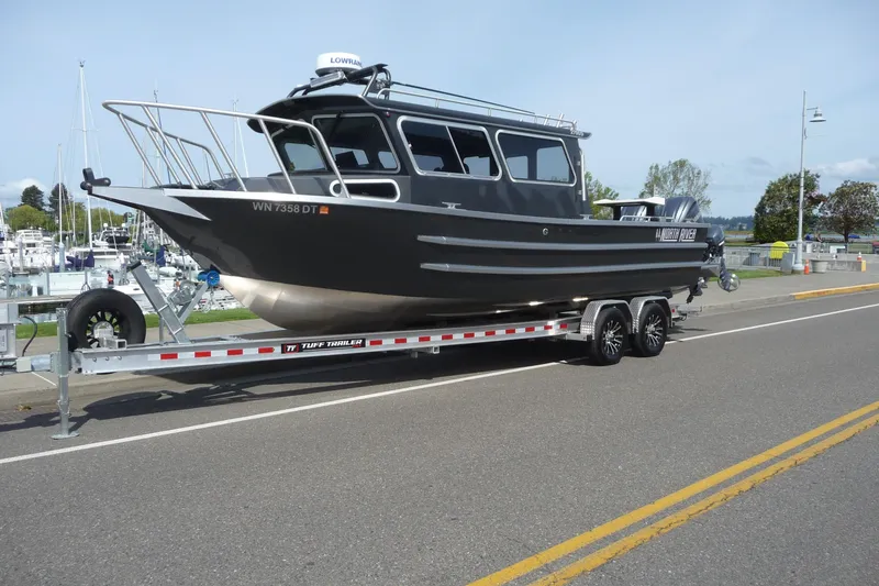 Slide: The Image of 2025 North River 2700s boat on trailer, parked near marina, ready for launch. - 2