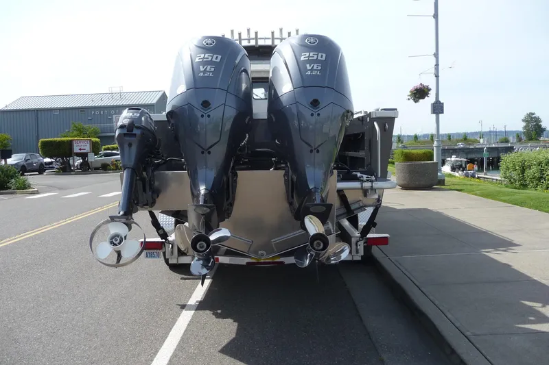 Slide: The Image of 2025 North River 2700s boat with dual Yamaha 250 V6 outboard engines, parked on a street. - 8