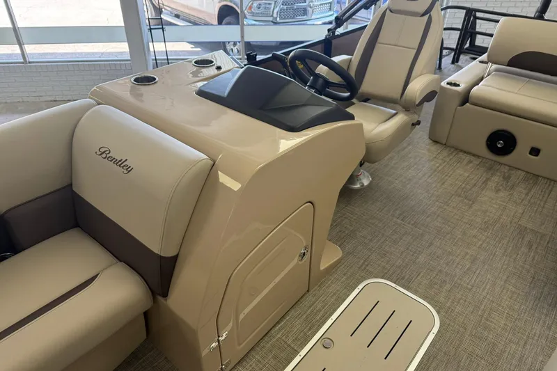 Slide: The Image of 2026 Bentley Pontoons Legacy 223 Swingback interior with beige seating and steering console. - 5
