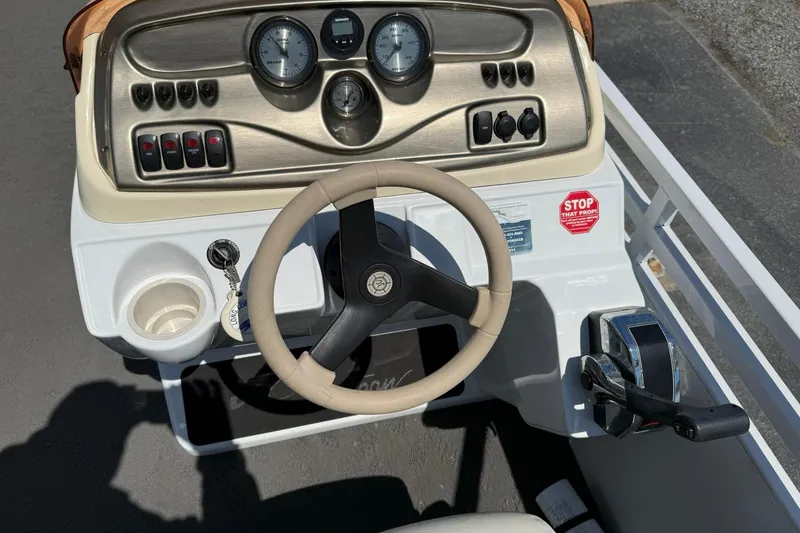 Slide: The Image of Steering console of a 2010 JC 21 Neptoon boat with gauges and controls. - 12