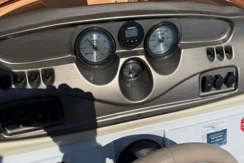 Slide: The Image of Dashboard of a 2010 JC 21 Neptoon boat with gauges and controls. - 13