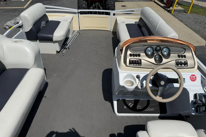 Slide: The Image of 2010 JC 21 Neptoon pontoon boat interior with steering console and seating. - 15