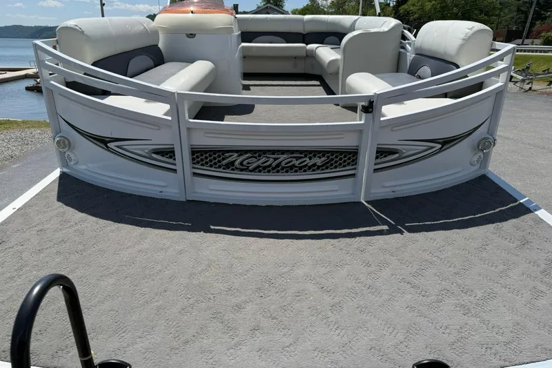 Slide: The Image of 2010 JC 21 Neptoon pontoon boat with spacious seating, docked by a lake. - 6