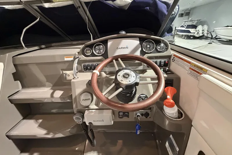 Slide: The Image of Cockpit of 2012 Regal 28 Express boat with Garmin navigation system and wooden steering wheel. - 16