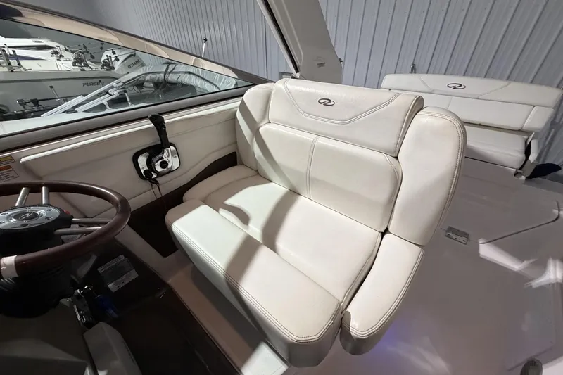 Slide: The Image of Interior of a 2012 Regal 28 Express boat with white seating and steering wheel. - 17