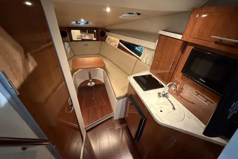 Slide: The Image of Luxurious interior of 2012 Regal 28 Express boat with kitchenette and seating area. - 19