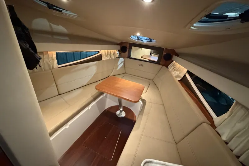 Slide: The Image of Interior of 2012 Regal 28 Express boat with beige seating and wooden table. - 20