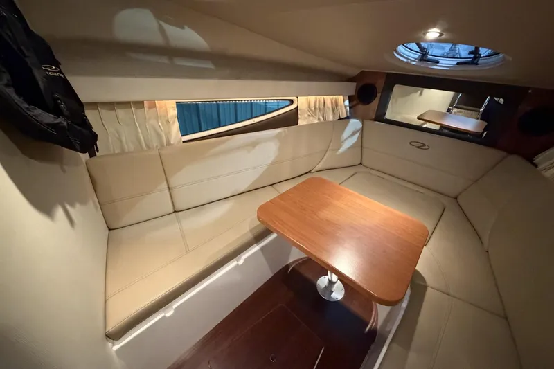 Slide: The Image of 2012 Regal 28 Express cabin interior with beige seating and wooden table. - 21