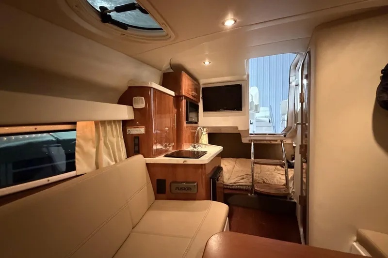 Slide: The Image of Interior of a 2012 Regal 28 Express boat with kitchenette and seating area. - 22