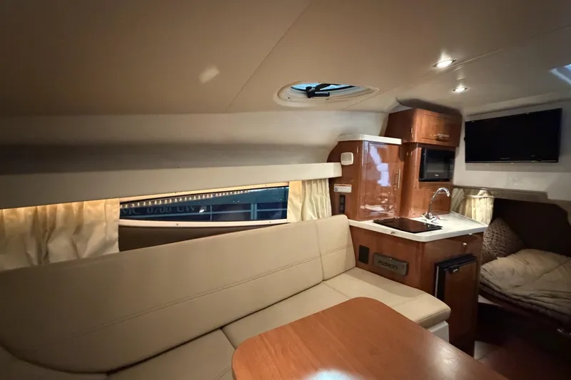 Slide: The Image of Interior of a 2012 Regal 28 Express boat with kitchenette and seating area. - 23