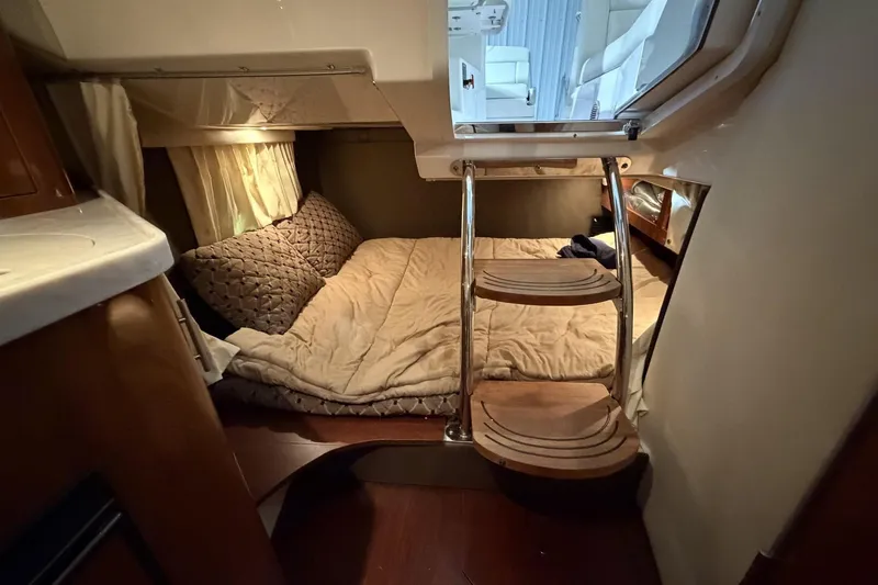 Slide: The Image of Cozy cabin interior of 2012 Regal 28 Express boat with bed and wooden steps. - 27