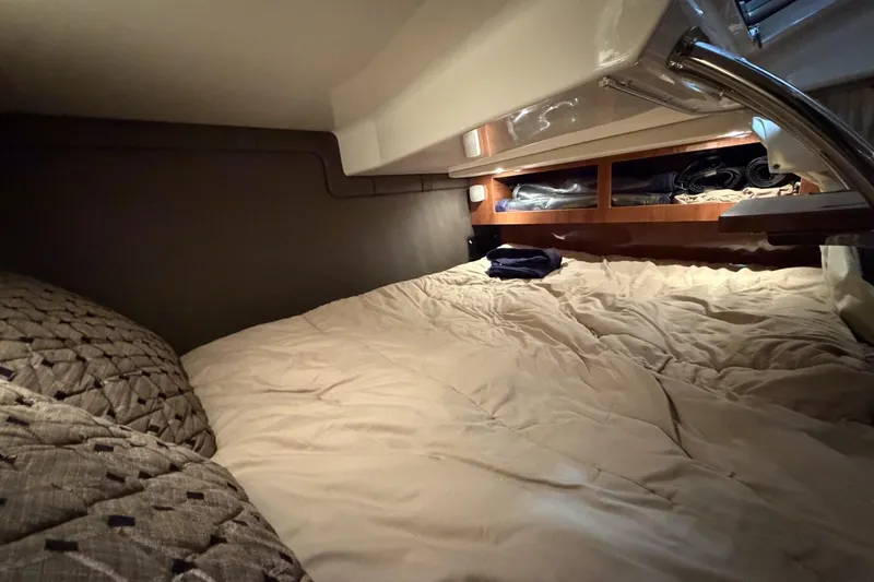 Slide: The Image of Cozy cabin interior of 2012 Regal 28 Express boat with comfortable bedding and storage. - 28