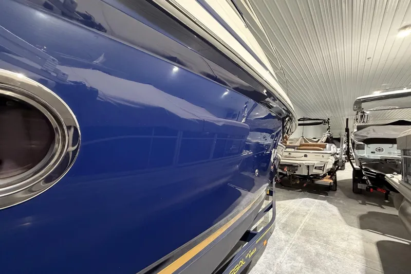 Slide: The Image of 2012 Regal 28 Express boat in storage, showcasing sleek blue hull and modern design. - 5