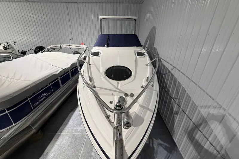 Slide: The Image of 2012 Regal 28 Express boat in storage, featuring sleek design and white exterior. - 8