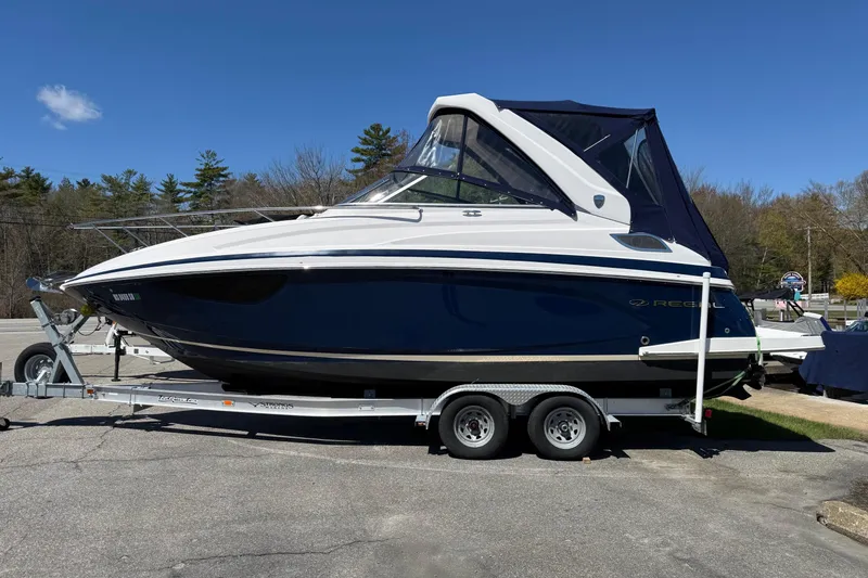 The Image of 2018 Regal 28 Express boat on trailer under clear blue sky. - 0