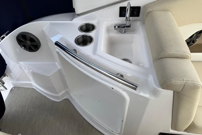 Slide: The Image of 2018 Regal 28 Express boat interior with sink, cup holders, and seating area. - 10