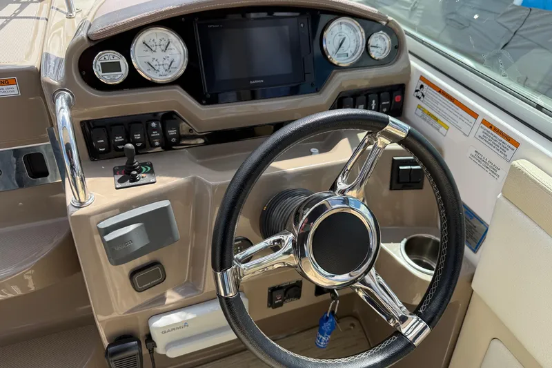 Slide: The Image of 2018 Regal 28 Express boat dashboard with steering wheel and navigation controls. - 12