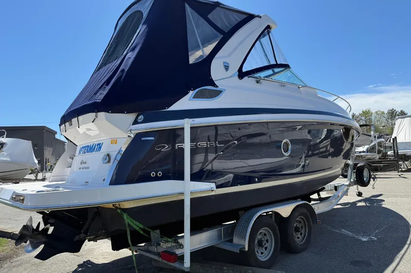 Slide: The Image of 2018 Regal 28 Express boat on trailer, featuring sleek design and navy canopy. - 4