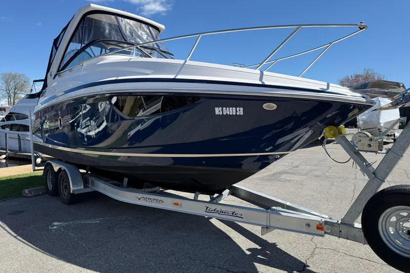 Slide: The Image of 2018 Regal 28 Express boat on trailer under clear blue sky. - 5