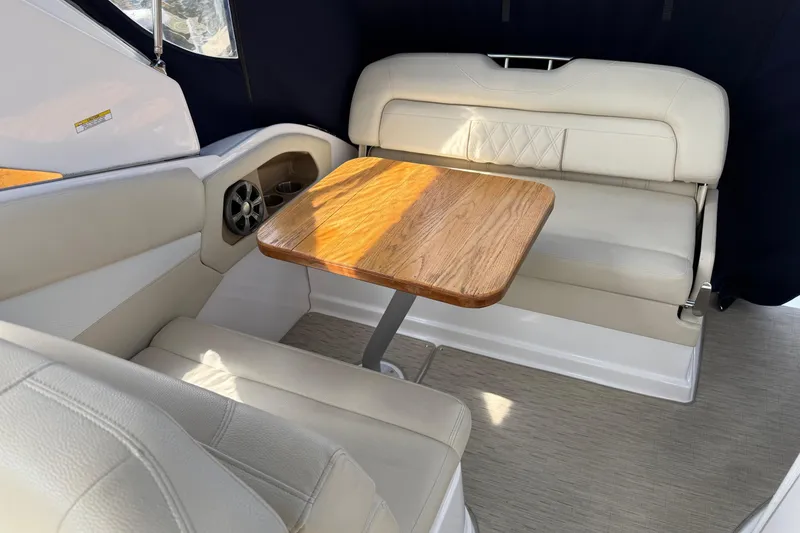 Slide: The Image of Interior of 2018 Regal 28 Express boat with beige seating and wooden table. - 9