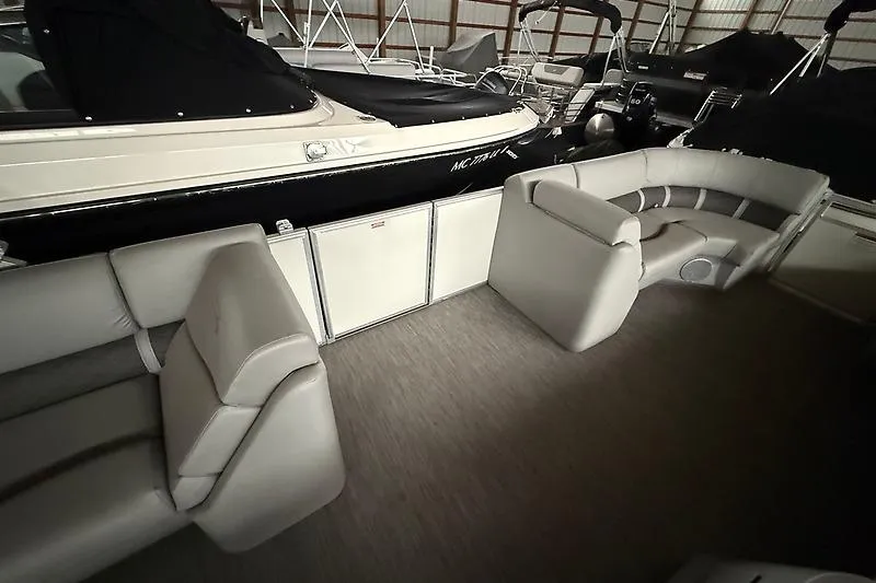 Slide: The Image of 2021 Bennington 25 SSBXSD pontoon boat interior with plush seating in storage. - 10