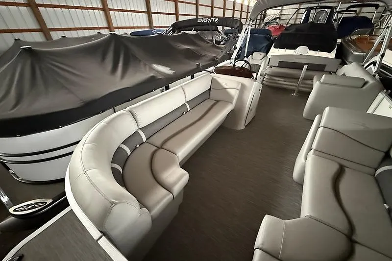 Slide: The Image of 2021 Bennington 25 SSBXSD pontoon boat with spacious seating in a covered storage area. - 12