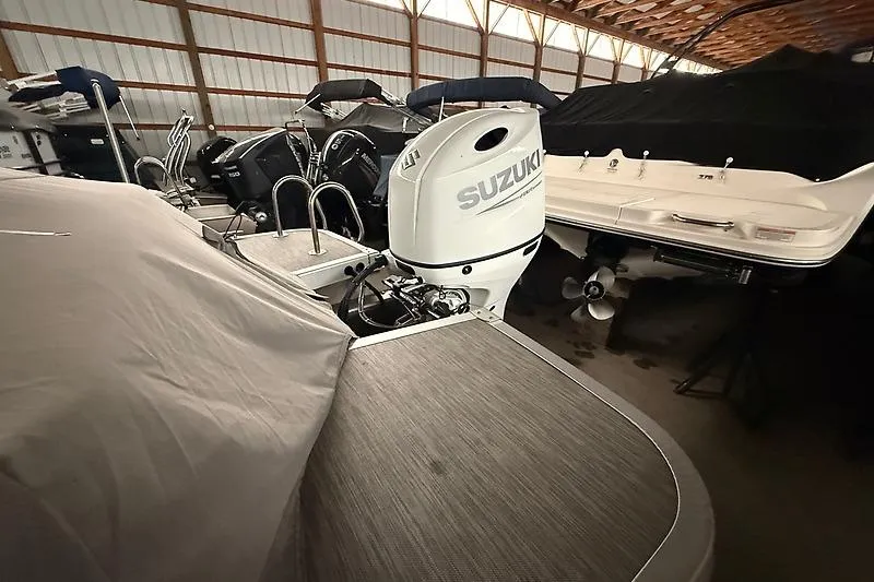 Slide: The Image of 2021 Bennington 25 SSBXSD boat with Suzuki outboard motor in storage facility. - 3